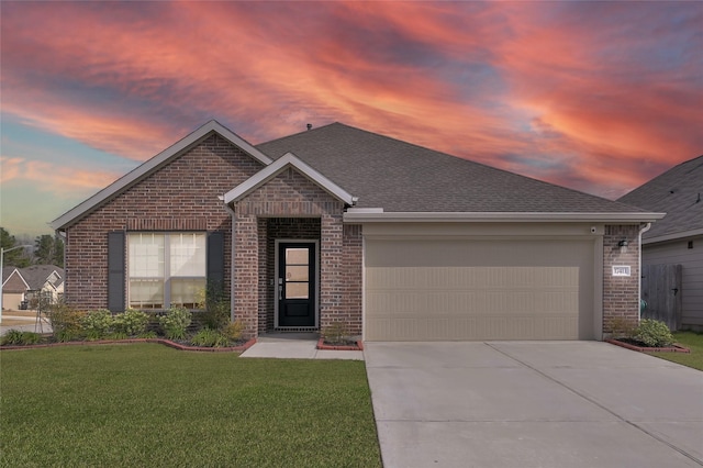 view of front of property with a garage and a yard