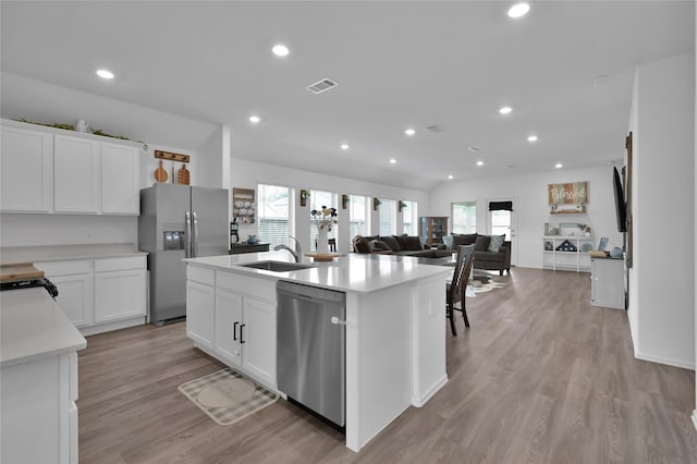 kitchen featuring appliances with stainless steel finishes, sink, white cabinets, a kitchen island with sink, and a healthy amount of sunlight