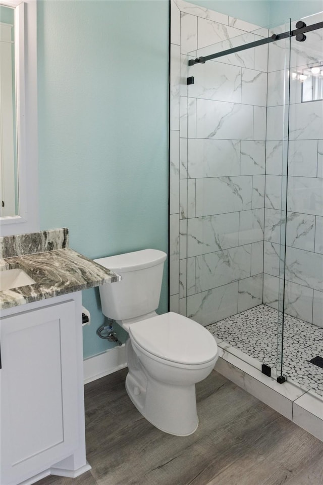 full bath with vanity, a shower stall, toilet, and wood finished floors