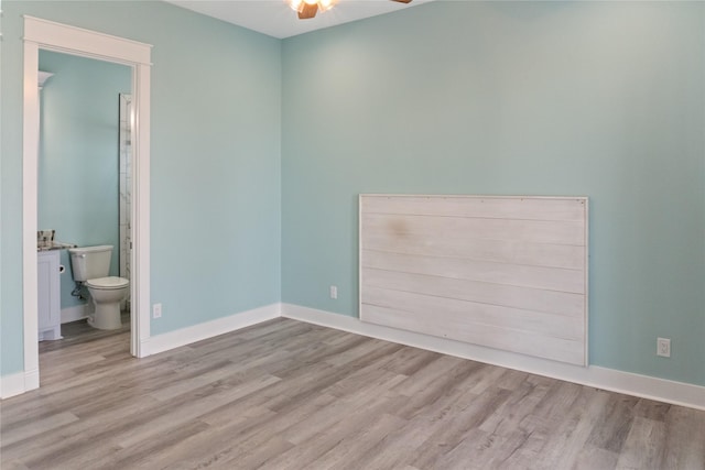 unfurnished bedroom featuring connected bathroom and light hardwood / wood-style flooring