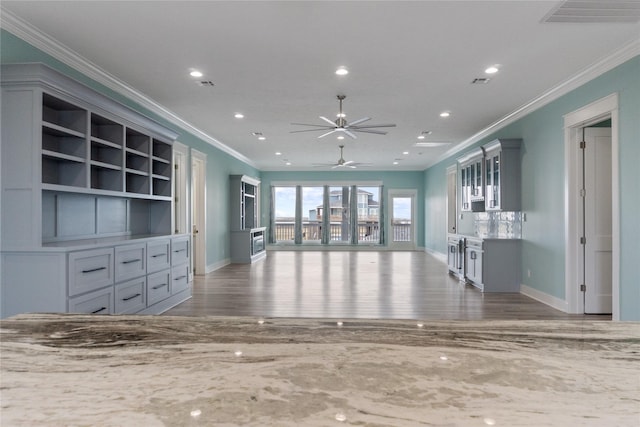 unfurnished living room featuring crown molding, wood finished floors, and recessed lighting