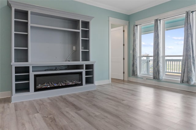 unfurnished living room featuring baseboards, wood finished floors, a glass covered fireplace, and crown molding