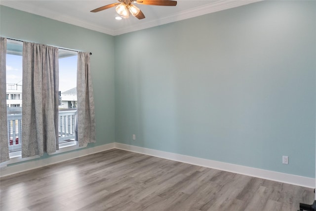 empty room with crown molding, baseboards, and wood finished floors