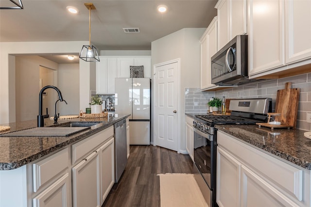 2230 Sand Lily Dr, Texas City, TX 77568 - kitchen featuring a sink, tasteful backsplash, stainless steel appliances, and dark wood finished floors