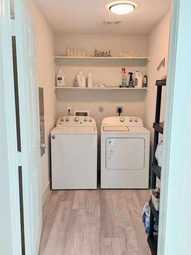 laundry area featuring washer and dryer and light wood-type flooring