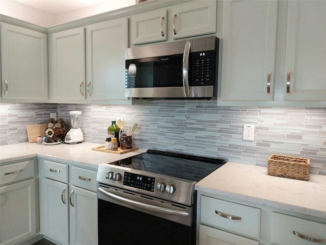 kitchen with appliances with stainless steel finishes, light stone countertops, and backsplash