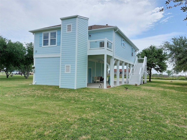 back of property with a lawn and a patio