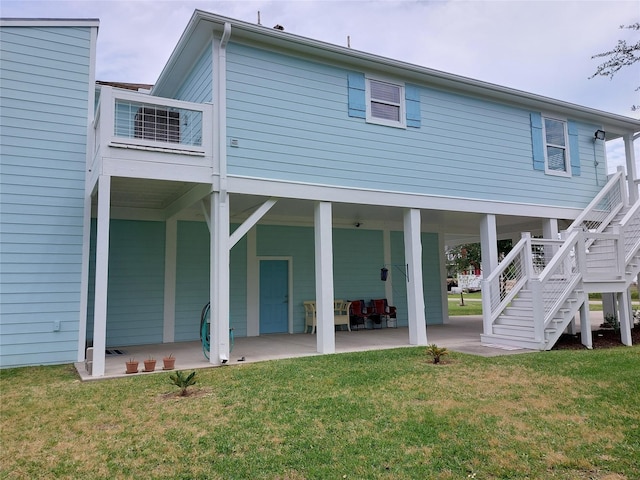 rear view of property with a yard and a patio area