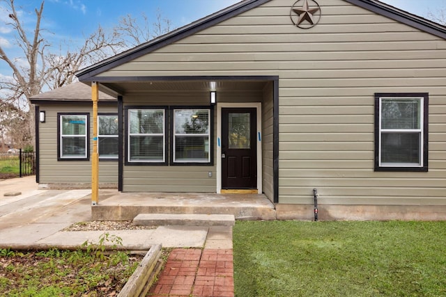 doorway to property featuring a lawn