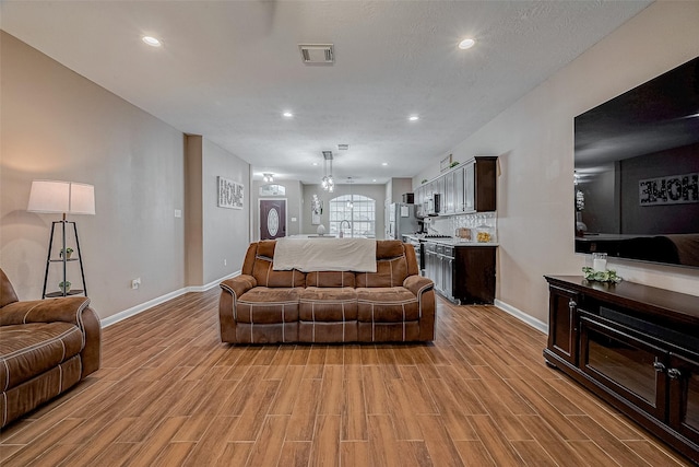 living room featuring sink and light hardwood / wood-style flooring