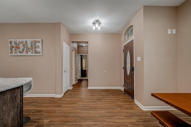 entrance foyer with light hardwood / wood-style flooring and a textured ceiling