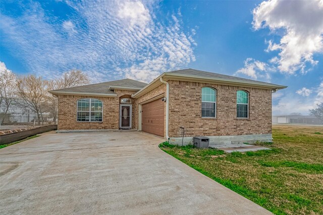 ranch-style home with a garage and a front lawn