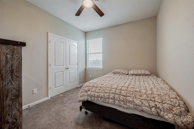 carpeted bedroom with ceiling fan and a closet