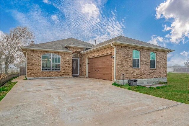 ranch-style home featuring a garage and a front yard