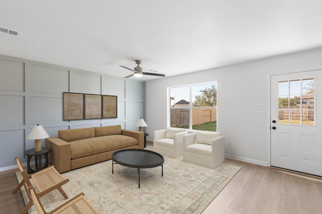 living room featuring ceiling fan and light hardwood / wood-style floors