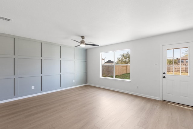 empty room with ceiling fan, a healthy amount of sunlight, and light wood-type flooring