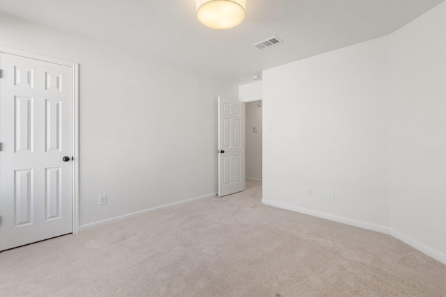 spare room featuring light colored carpet