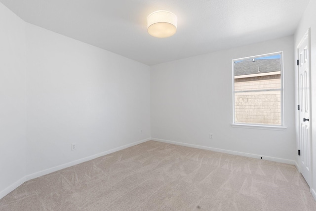 spare room featuring light colored carpet