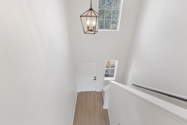 hall with a notable chandelier and light wood-type flooring