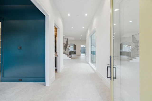 hall featuring stairs, baseboards, and recessed lighting