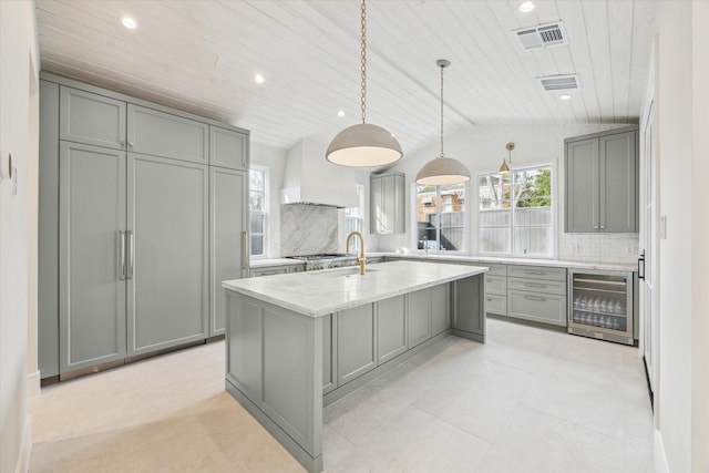 kitchen featuring gray cabinets, beverage cooler, custom range hood, and pendant lighting