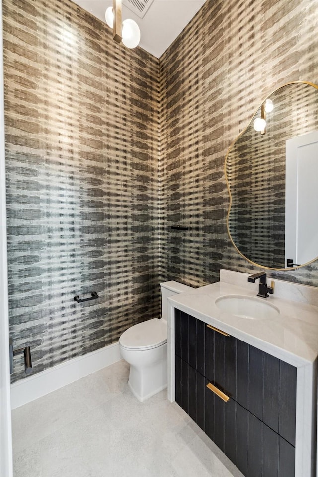 bathroom with toilet, tile patterned flooring, and vanity