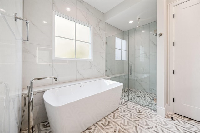 bathroom featuring a soaking tub, tile walls, and a marble finish shower