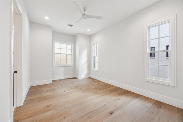 spare room featuring baseboards, visible vents, and light wood finished floors