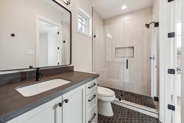 bathroom featuring tile patterned flooring, toilet, recessed lighting, vanity, and a shower stall