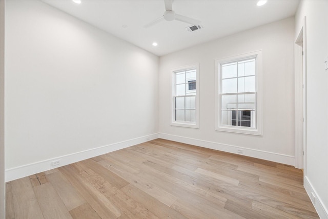 empty room with light wood finished floors, baseboards, visible vents, and a ceiling fan