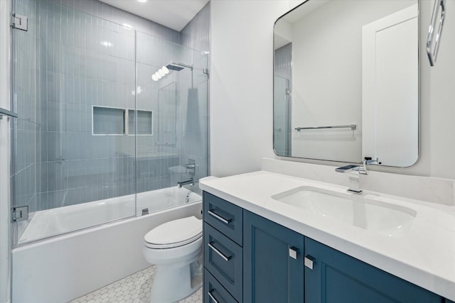 full bathroom featuring toilet, bath / shower combo with glass door, tile patterned flooring, and vanity