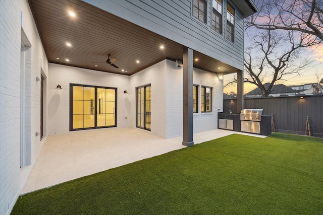 exterior space with exterior kitchen, a patio area, fence, and a ceiling fan