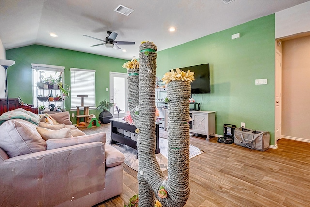 living room with ceiling fan, lofted ceiling, and light wood-type flooring