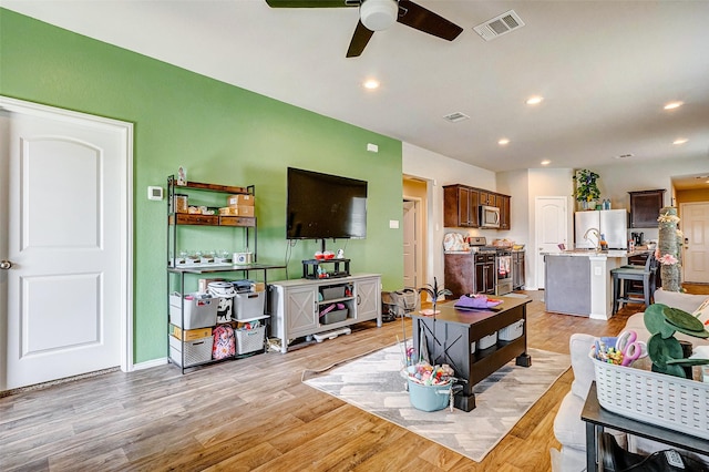 living room featuring ceiling fan and light wood-type flooring