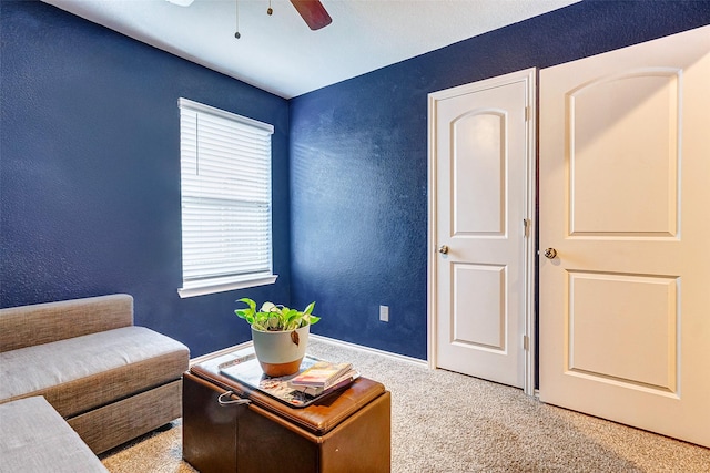 sitting room featuring light carpet and ceiling fan