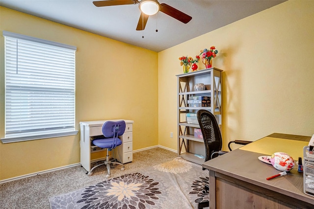 carpeted home office featuring ceiling fan