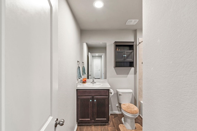 bathroom featuring hardwood / wood-style flooring, vanity, and toilet