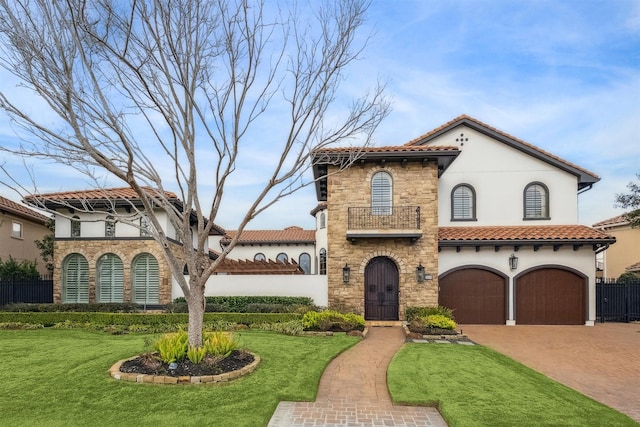 mediterranean / spanish house featuring a garage, a balcony, and a front yard