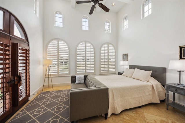 bedroom with ceiling fan and a high ceiling