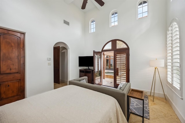 bedroom featuring ceiling fan and a towering ceiling