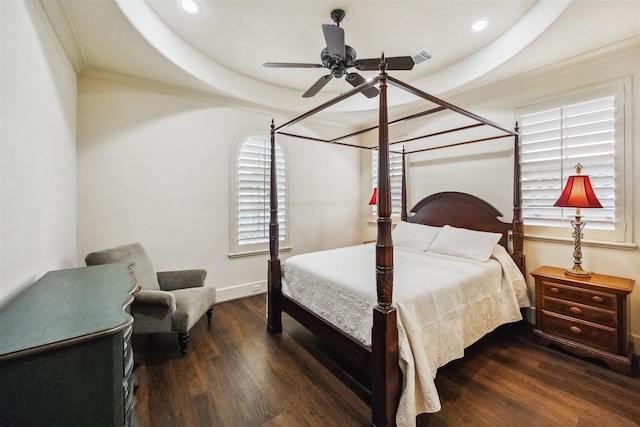 bedroom featuring a tray ceiling, dark hardwood / wood-style floors, and ceiling fan