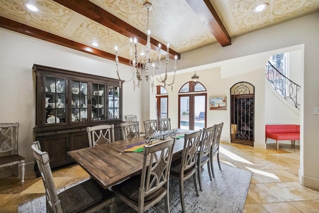 dining space with beamed ceiling, a chandelier, and french doors