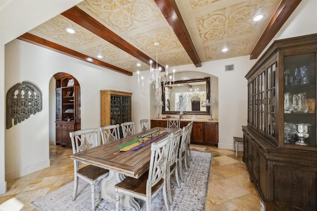 dining area with an inviting chandelier and beamed ceiling