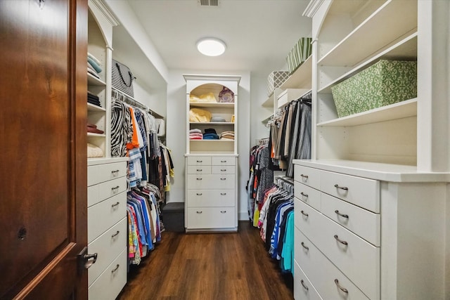 walk in closet with dark hardwood / wood-style floors