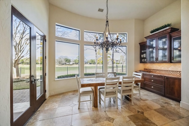 dining space with a towering ceiling and a notable chandelier