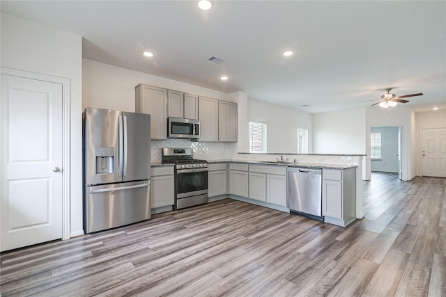 kitchen featuring a healthy amount of sunlight, stainless steel appliances, kitchen peninsula, and sink