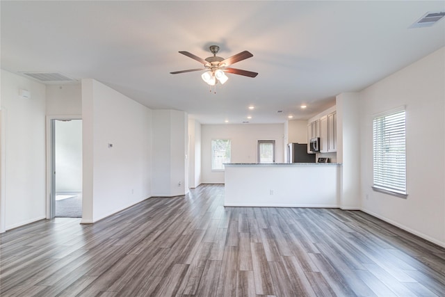 unfurnished living room with ceiling fan and light wood-type flooring