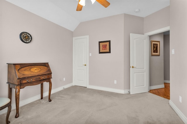 interior space with ceiling fan, lofted ceiling, and light carpet