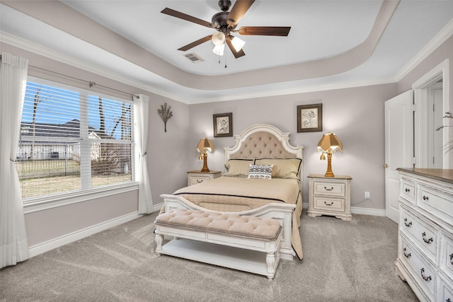 carpeted bedroom featuring a raised ceiling, crown molding, and ceiling fan