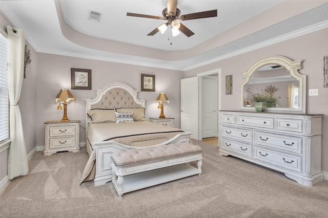 bedroom with ceiling fan, ornamental molding, a raised ceiling, and light carpet